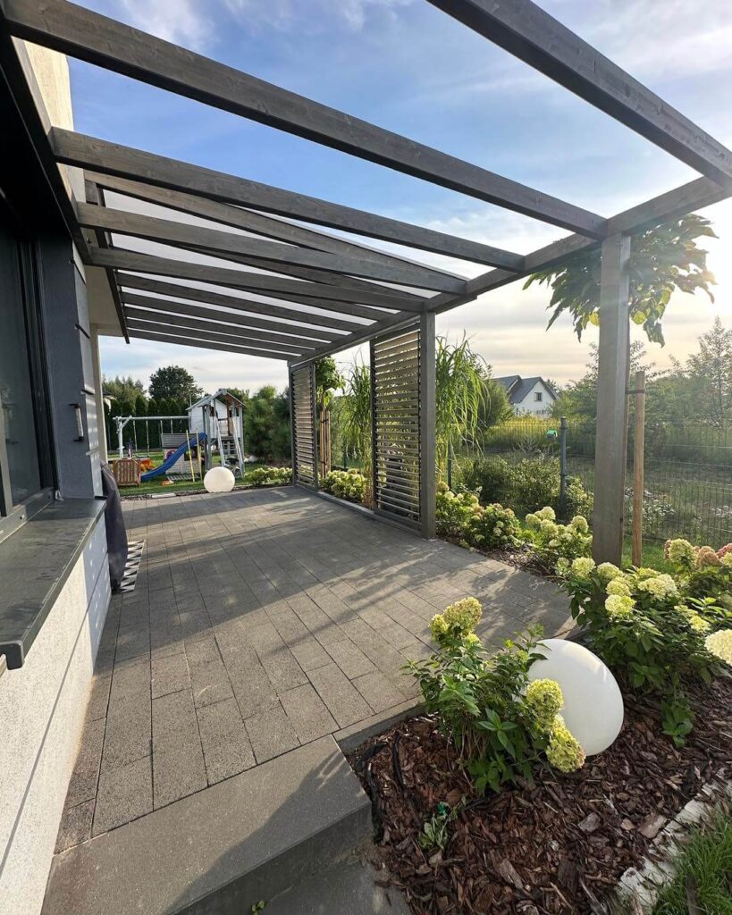 Grafitowa pergola na tarasie z kostki